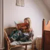 Dziewczynka czyta książkę "Słomka kotek,który chciał być sobą" Katarzyny Ogonowskiej.